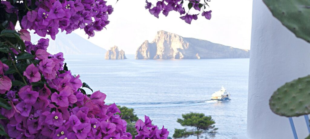 Bougainvillea and the Panarea islets, a classic Mediterranean island view, Italy