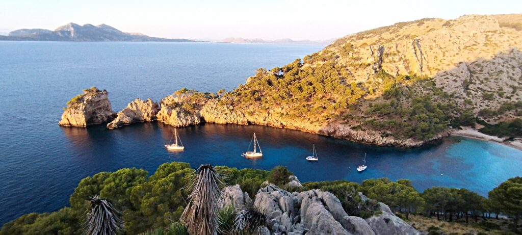 Travesía silenciosa Menorca — Primera luz sobre los acantilados del fondeadero
