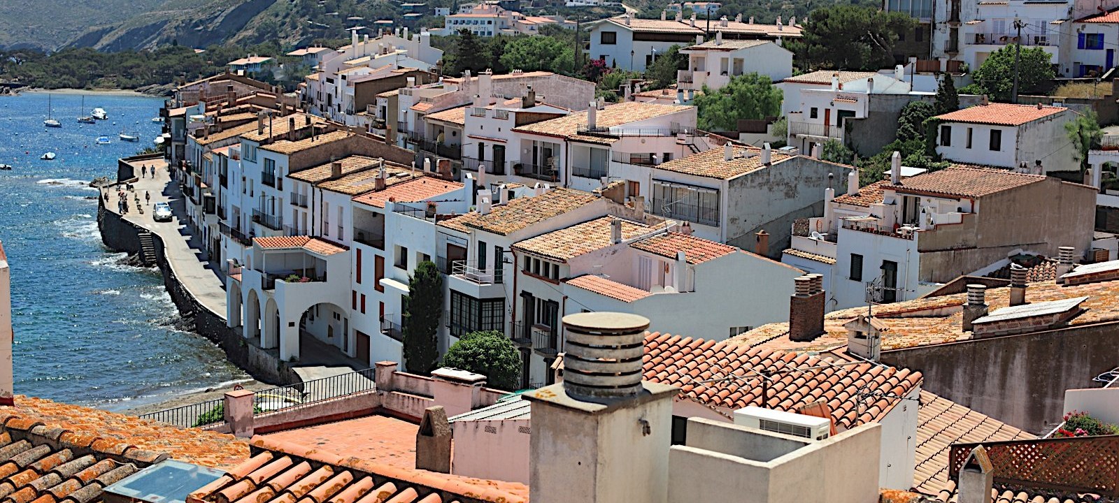 Rooftops of Cadaqués and boats at anchor in the bay