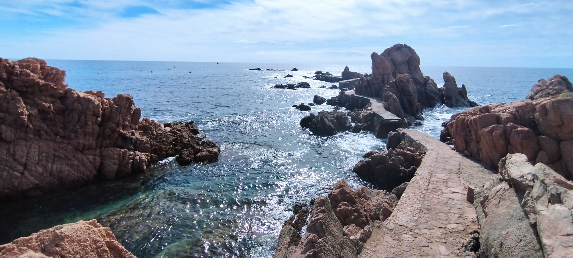 Red rock of the Costa Brava and the coastal path at the water's edge