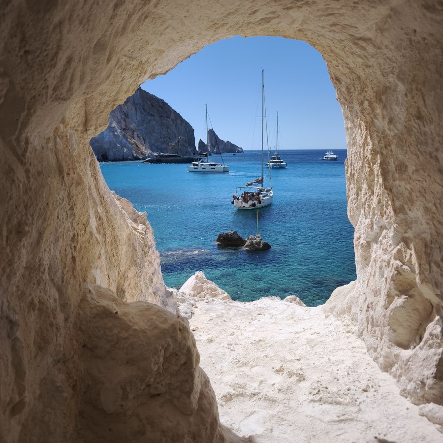 Sea cave opening onto anchored yachts