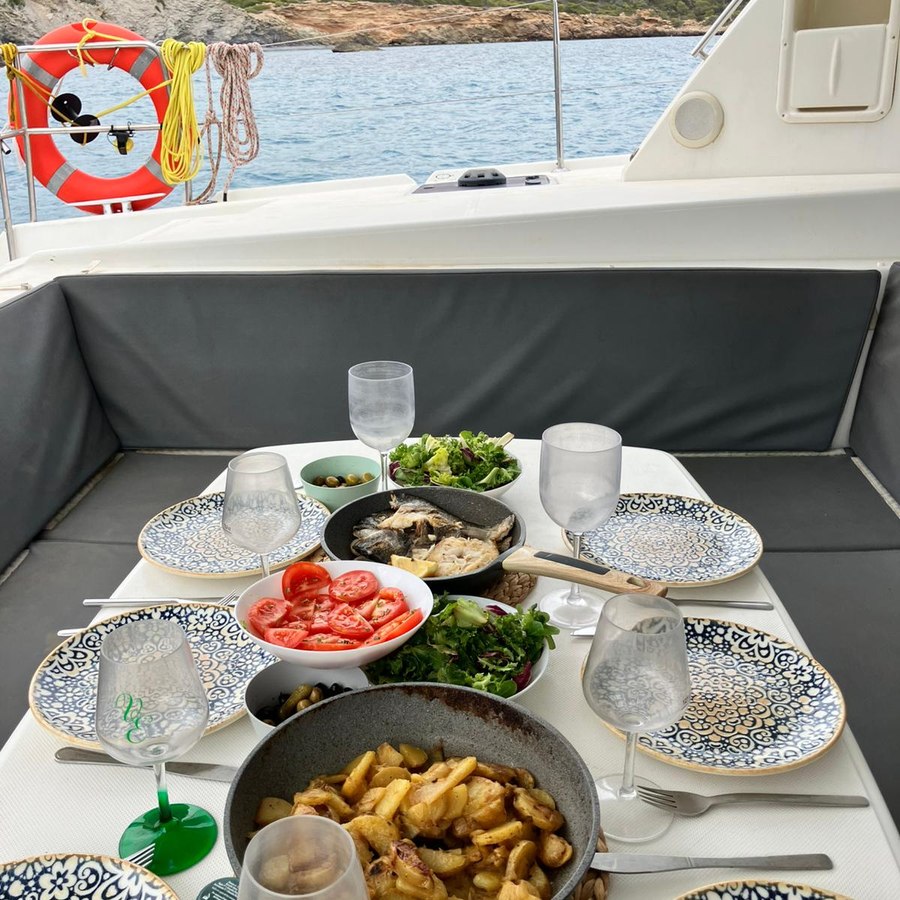 Table laid in a cockpit: fish, tomatoes, salads