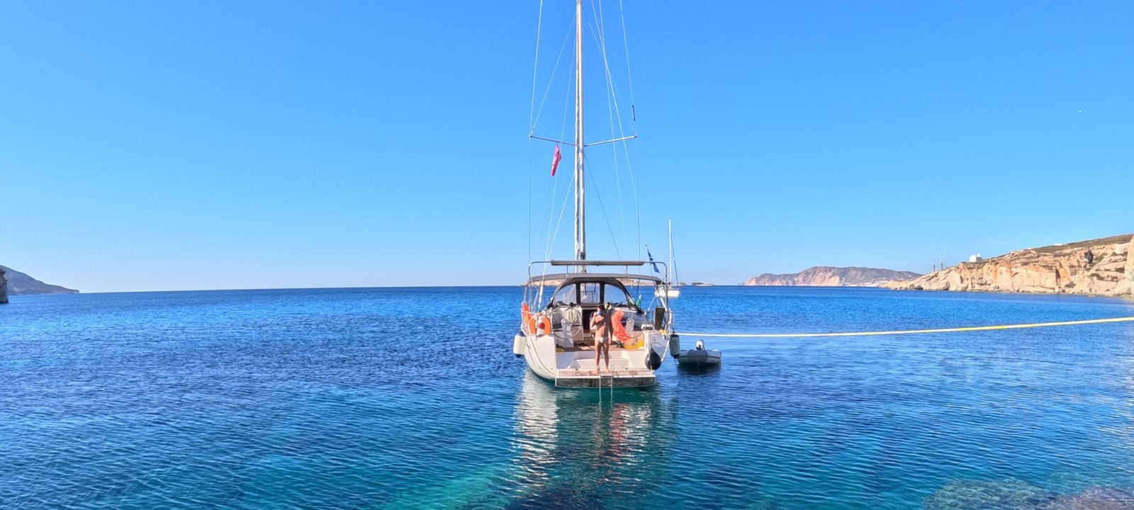 Yacht at anchor over transparent water