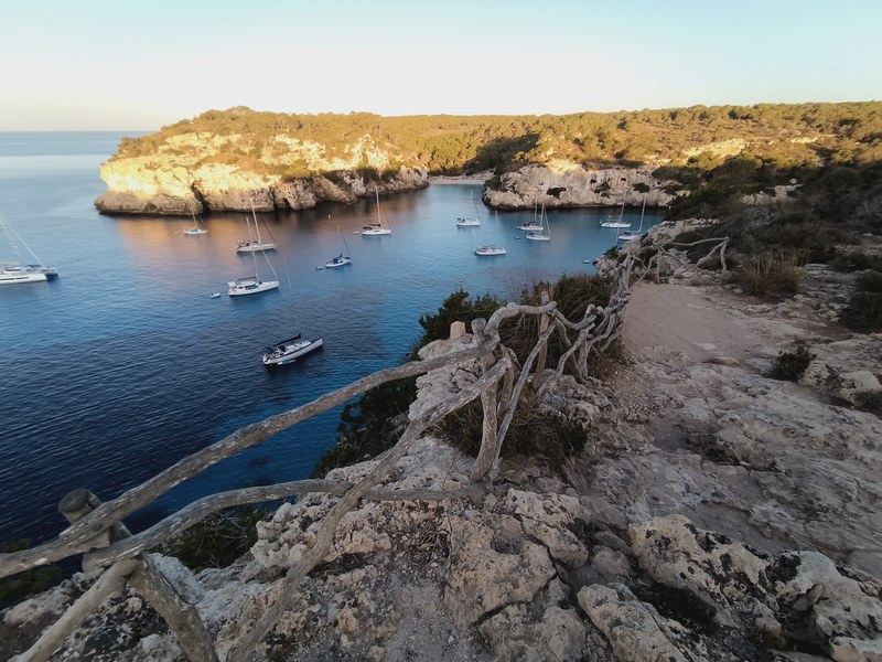 Yachts anchored at dawn below the coast path, south coast of Menorca