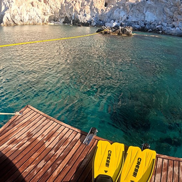 The cliff at Kalogiros on Polyaigos, turquoise water and fins on the transom
