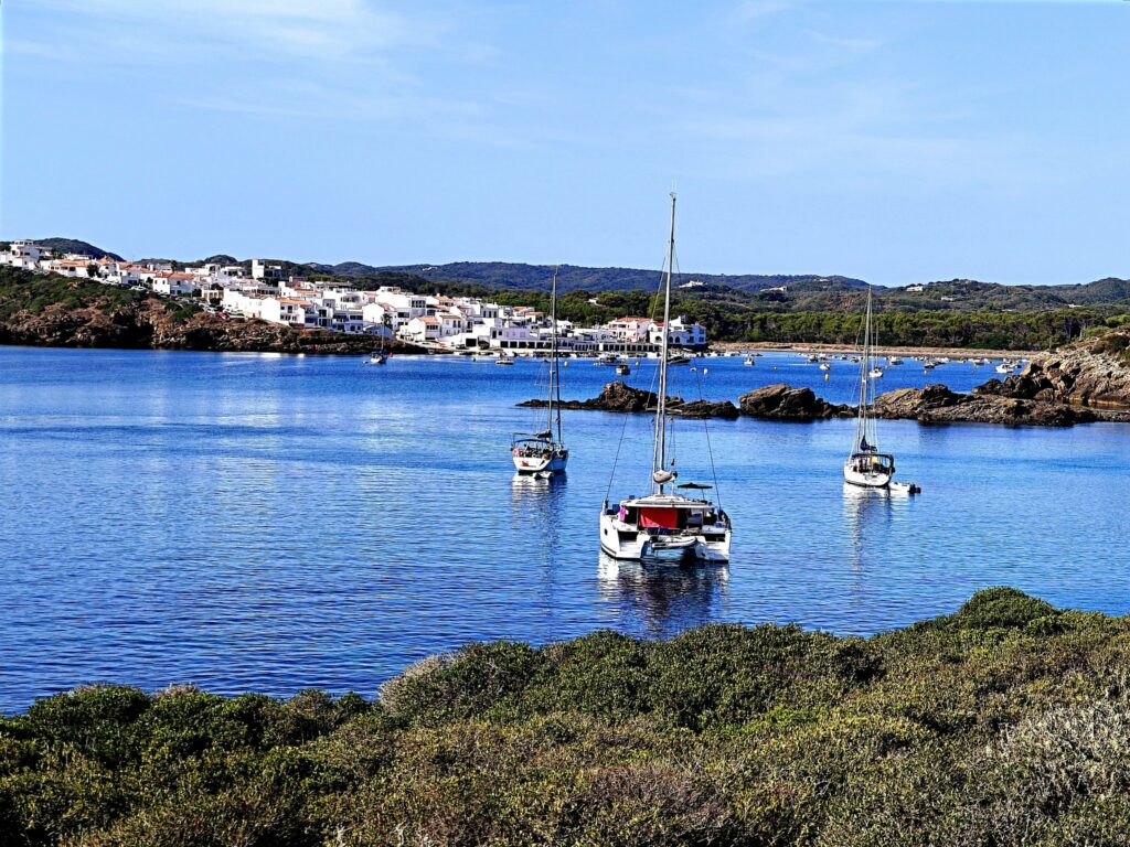 The Quiet Passage Menorca — At anchor off Es Grau, between Illa d'en Colom and the village